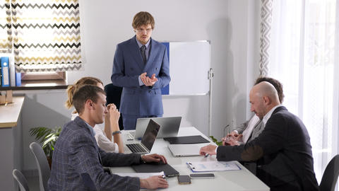 Meeting of the company's directors. The briefing. A man in a suit stands in front of a whiteboard
