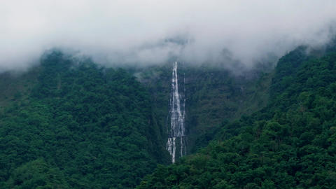 Aerial view misty foggy mountain landscape with clouds and waterfall