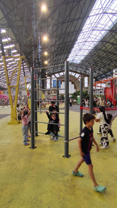 Children exploring colorful indoor playground with spiral slide