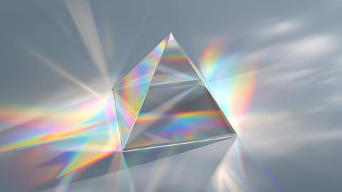 Glass prism dispersing light into rainbow spectrum on soft gray background