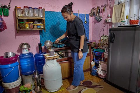 A Woman Engaged in Household Chores in a Colorful Kitchen, Emphasizing Daily