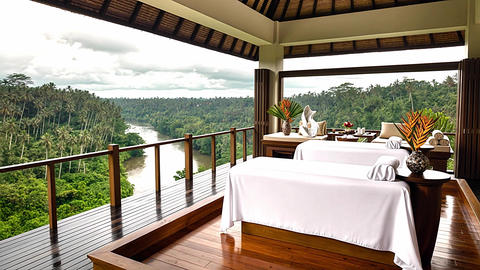 Luxury outdoor spa salon with massage tables and panoramic view of tropical jungle and river