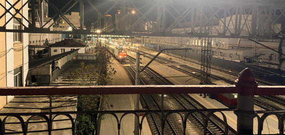Night view of railway tracks with passing train from bridge