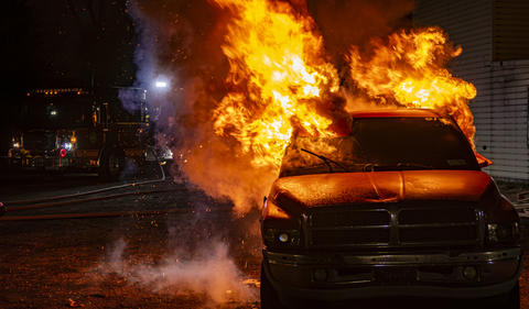 Firefighters Respond to Car Fire at Night in a Rural Area Near a Building