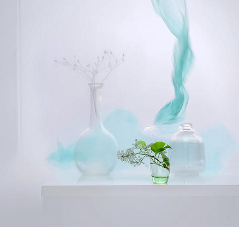Glass vases, lilac flowers, and teal smoke minimal still life