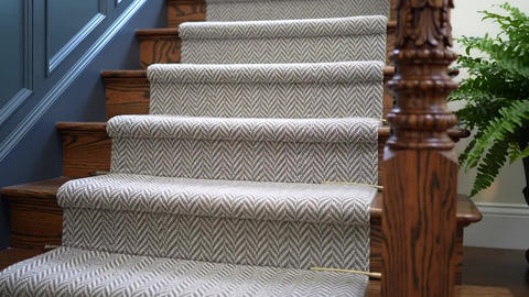 A close-up shows a carpeted staircase with dark wood steps and decor
