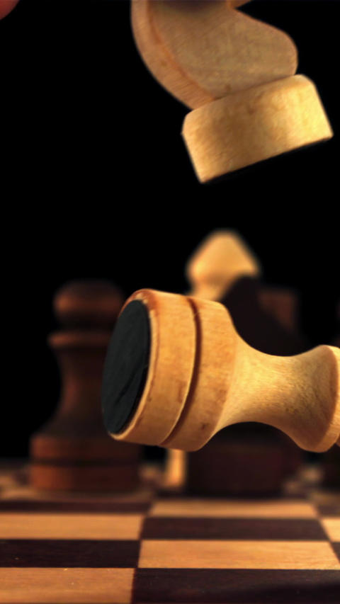 Super slow motion man's hand knocks the chess piece off the board. Filmed on a