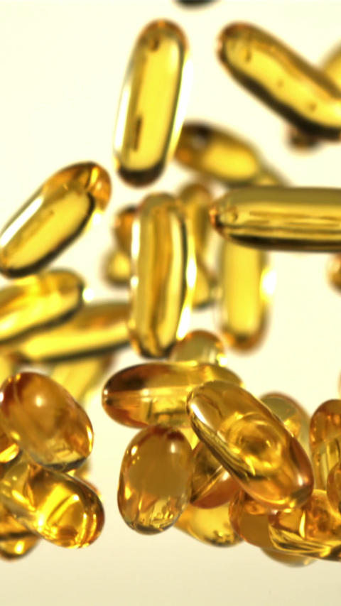 Omega 3 vitamin capsules rise and fall. Filmed is slow motion 1000 fps