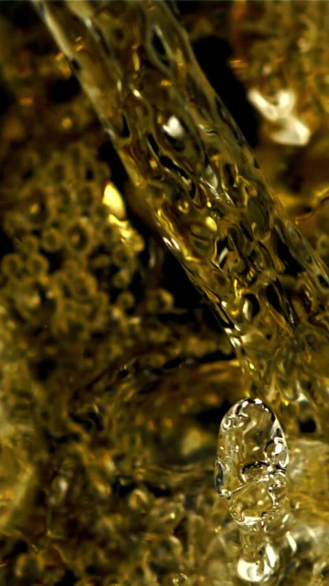 Champagne with air bubbles pours into the glass. Top view. Filmed is slow motion