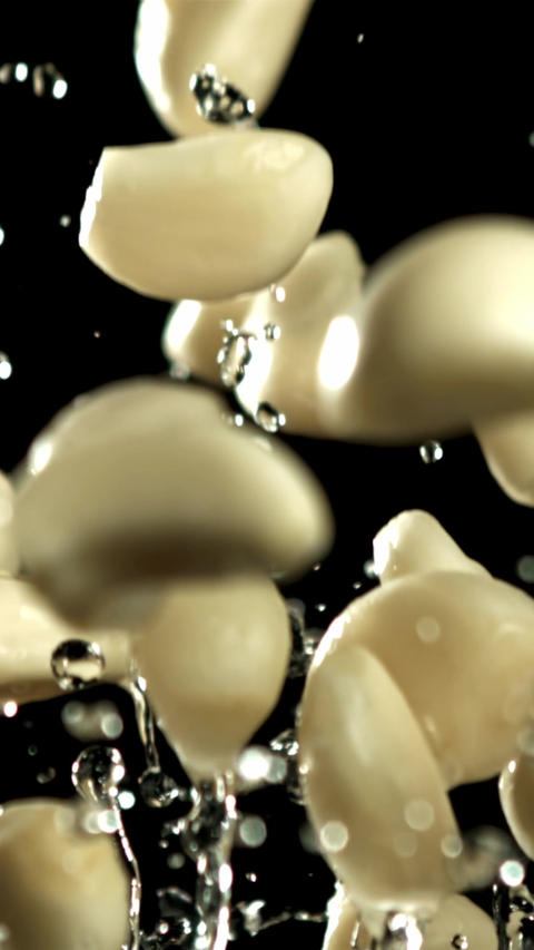 Garlic flies up with drops of water. Filmed on a high-speed camera at 1000 fps