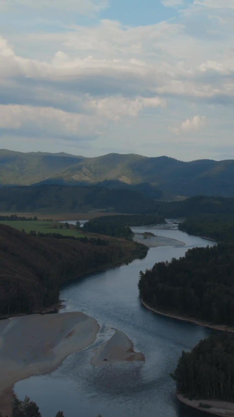 Aerial view of winding river and forested mountains near Zamulta, Altai
