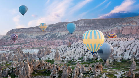 Colorful hot air balloons flying over rock landscape at Cappadocia Turkey