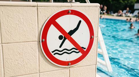 No diving sign at a swimming pool showing safety rules for swimmers during summer