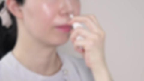 Blurred Shot of Asian Woman Using Nasal Spray for Allergy Relief. 4K