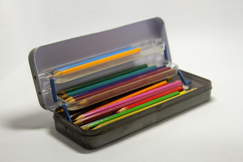 Vintage metal pencil case with colorful drawing pencils on white background