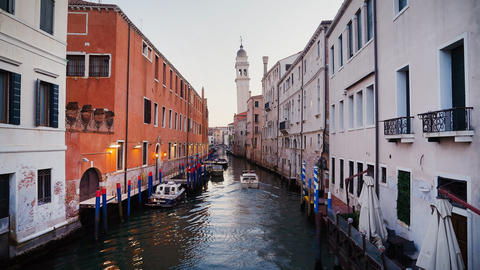 Venice canal view with leaning bell tower at peaceful evening. San Giorgio dei Greci church
