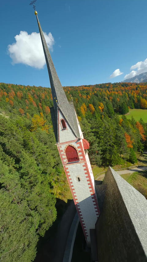 Church of St. Jacob and mountains on the background filmed with FPV drone. Italy