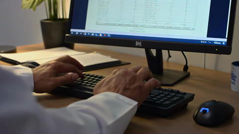Doctor typing patient diagnosis close-up at clinic workstation, entering medical notes into digital