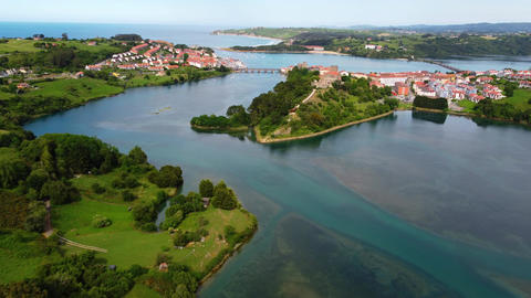 Wide aerial panoramic view of San Vicente de la Barquera estuary and coastline
