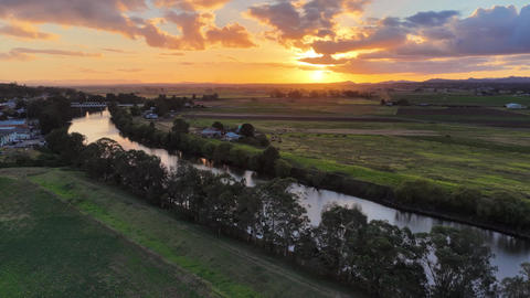 Aerial video flying along the Hunter River at Morpeth, NSW, Australia, towards sunset