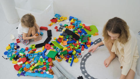 Two sisters playing with large colorful block set