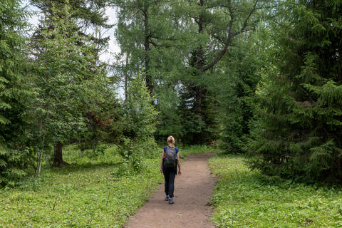 Woman hiking on forest trail near Manzherok Mountain in the Altai Mountains