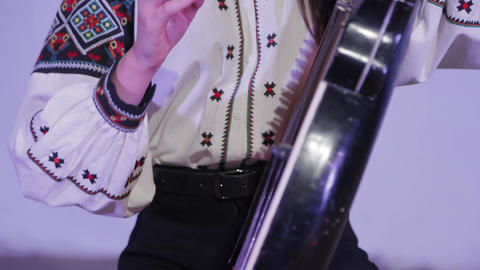 Musician in traditional blouse playing kobza musical instrument