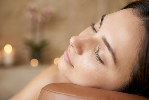 Relaxed woman resting her head on a massage table at a spa