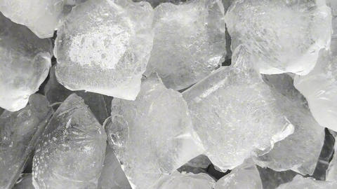 Camera flyover above large clear ice cubes macro texture