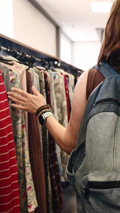 Woman With Denim Backpack Walking In Second Hand Shop