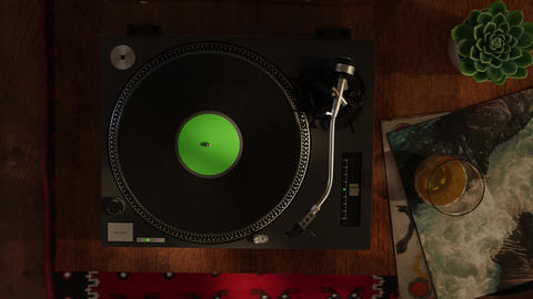 Retro turntable with green screen center label from a top view in the evening sunlight