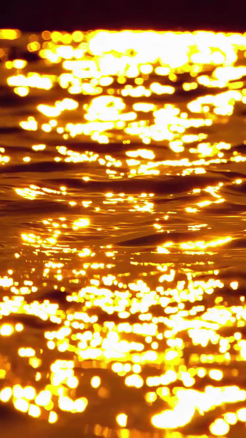 Sea of gold water surface with sparkling sun glares