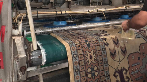Textile carpet cleaning in an industrial machine