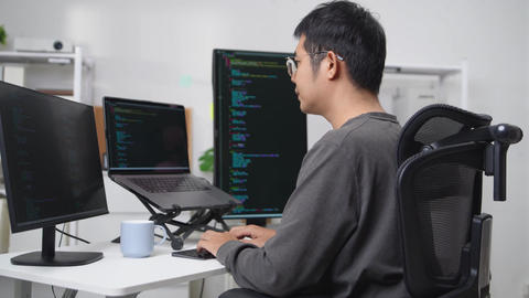 Focused Developer Working Remotely with Multiple Monitors Displaying Code and