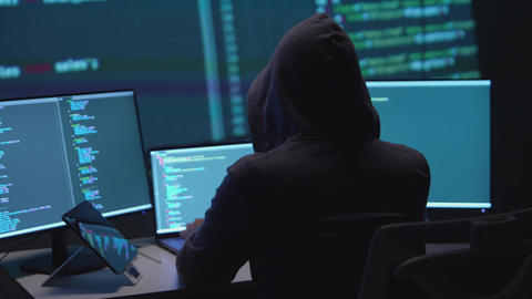 Anonymous Hacker Programming on Dual Monitors in a Low-Light Environment