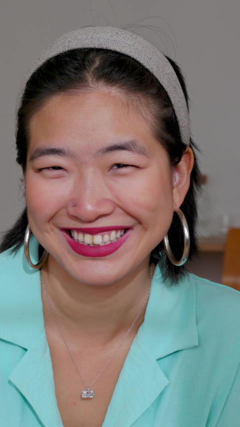 Smiling portrait of young adult asian woman at home