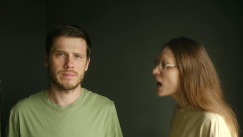 Frustrated woman yelling at a stoic man during an argument