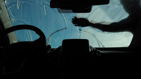 Car interior during windshield wash with soapy streaks