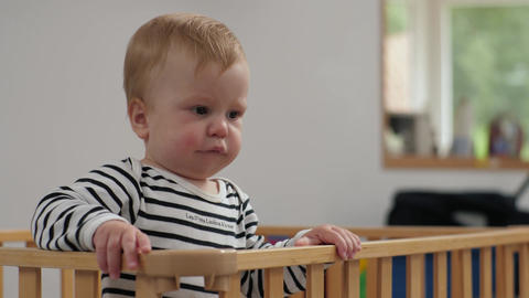 Curious caucasian baby in wooden crib