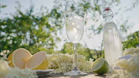 Dolly Shot Of Rustic Garden Table With Elderflower Lemonade Ingredients and Glassware