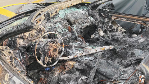 Burned car interior showing steering wheel and dashboard damage