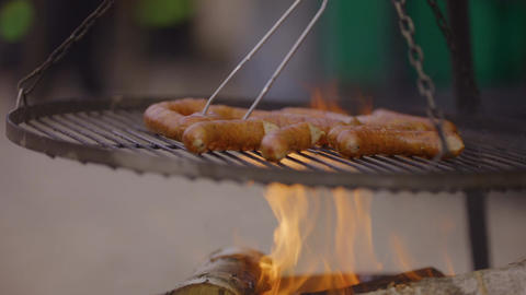 Grilled sausages cooking on a barbecue rack