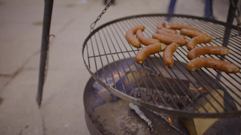 Grilled sausages cooking on a barbecue rack