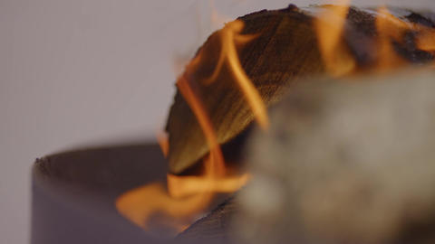 Bright orange flames rising over a dark burning surface