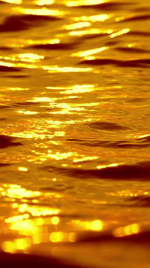 Golden ocean waves with sunset sun path reflection, sparkles and bokeh