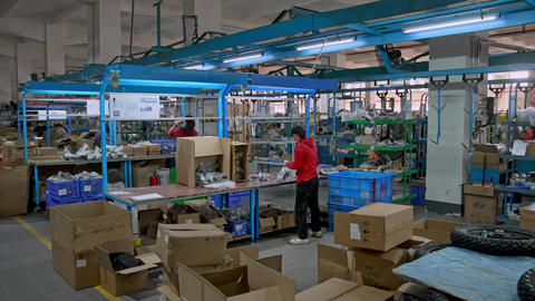 Industrial Factory Asian Workers Packing Finished Products into Cardboard Boxes