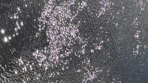Bright sunlight reflects off the surface of the water. A sparkling, endless expanse of water