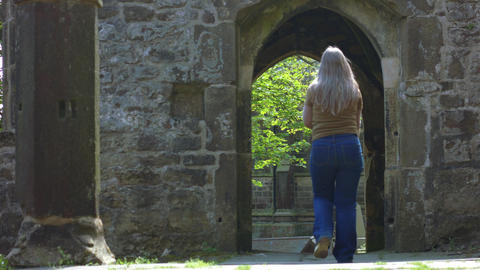 Woman tourist walking in archway of Saint Thomas a Becket Abbey Church