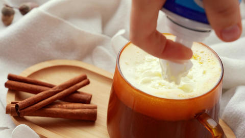 Adding whipped cream Autumn hygge Orange Cup of warm coffee autumn leaves on