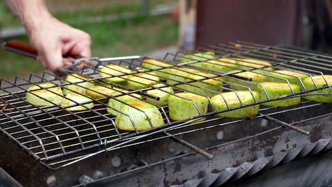 Chopped zucchini and carrots roasting on fire seasoned with aroma herbs and